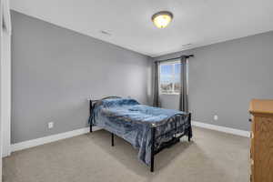 Carpeted bedroom with a textured ceiling