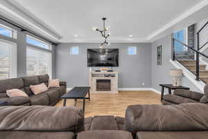 Living room featuring a chandelier, a textured ceiling, and light hardwood / wood-style floors