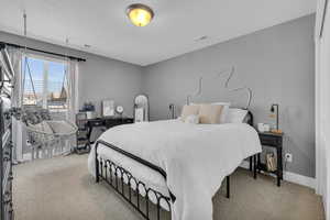 Carpeted bedroom featuring a textured ceiling