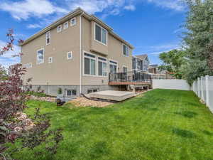 Back of house featuring a fenced backyard, a wooden deck, and stucco siding