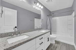 Full bathroom featuring vanity, shower / bath combo with shower curtain, and toilet