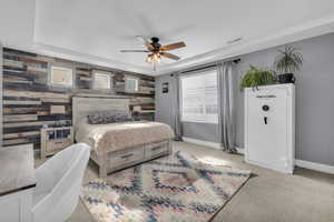 Bedroom featuring ceiling fan, light carpet, and wood walls