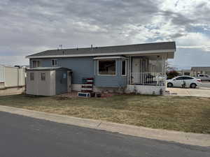 View of front of home with an outbuilding and a front yard