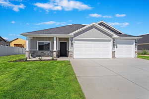 View of front of property featuring a garage, a front lawn, and covered porch