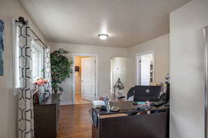 Office with hardwood / wood-style flooring and a textured ceiling