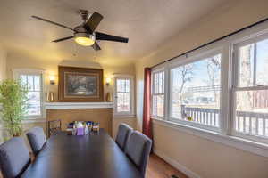 Dining area featuring ceiling fan, wood-type flooring, and a textured ceiling