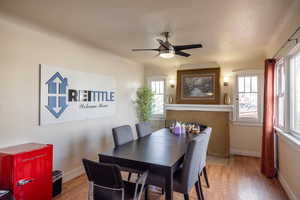 Dining room featuring ceiling fan, a textured ceiling, and wood-type flooring