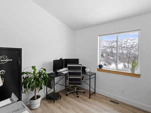 Office with light hardwood / wood-style flooring.