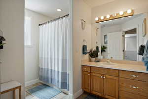 Bathroom featuring a shower with curtain, vanity, and tile patterned flooring