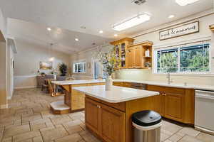 Kitchen with a kitchen island, pendant lighting, dishwasher, lofted ceiling, and sink