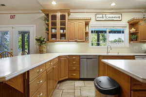 Kitchen featuring dishwasher, sink, a breakfast bar, and kitchen peninsula