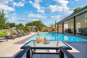 View of swimming pool with a shed and a patio