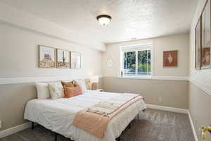 Bedroom featuring carpet flooring and a textured ceiling