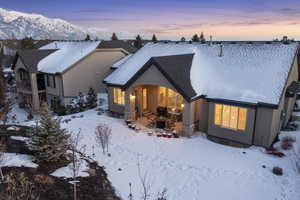 Snow covered rear of property featuring a mountain view