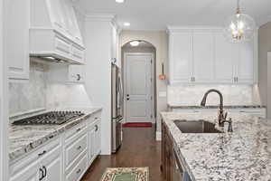 Kitchen featuring white cabinetry, appliances with stainless steel finishes, sink, and tasteful backsplash