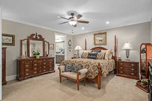 Carpeted bedroom featuring ensuite bathroom, crown molding, and ceiling fan