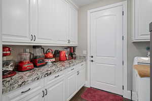 Kitchen with light stone countertops and white cabinets