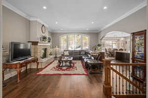 Living room featuring ornamental molding, a healthy amount of sunlight, and dark hardwood / wood-style floors