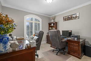 Carpeted home office with ornamental molding