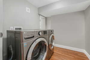 Laundry area featuring independent washer and dryer and light hardwood / wood-style floors