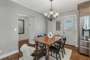 Dining space featuring a notable chandelier and dark hardwood / wood-style flooring