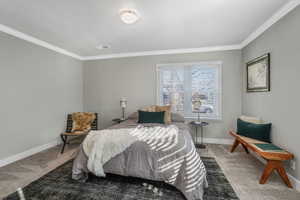 Bedroom with ornamental molding and carpet