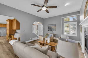 Living room with ceiling fan and light wood-type flooring