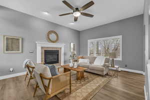 Living room with hardwood / wood-style flooring, a fireplace, and ceiling fan