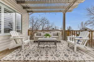 Wooden terrace with an outdoor living space and a pergola