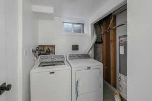 Laundry room featuring washing machine and dryer and gas water heater