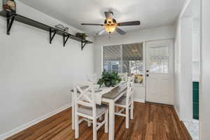 Dining room featuring dark hardwood / wood-style flooring, a textured ceiling, and ceiling fan