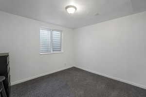 Carpeted empty room featuring a textured ceiling