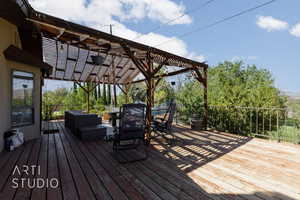 Wooden terrace featuring an outdoor living space and a pergola