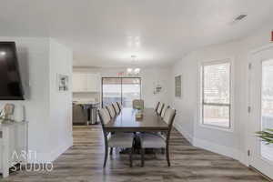 Dining room with hardwood / wood-style flooring, plenty of natural light, and a chandelier