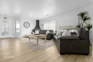 Living room featuring a wealth of natural light, a textured ceiling, and light hardwood / wood-style flooring