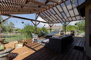 Wooden deck featuring a pergola and an outdoor hangout area