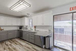 Kitchen featuring dishwasher, white cabinetry, sink, and gray cabinetry