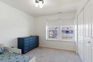 Carpeted bedroom with a closet