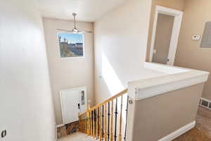 Staircase featuring carpet and ceiling fan