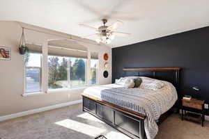 Carpeted bedroom featuring ceiling fan