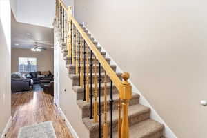 Staircase featuring wood-type flooring and ceiling fan