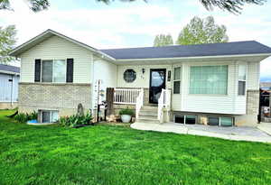 Raised ranch with covered porch and a front lawn