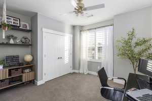 Office area featuring visible vents, a ceiling fan, baseboards, and carpet