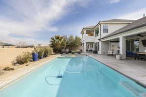 View of swimming pool featuring french doors, ceiling fan, and a patio area