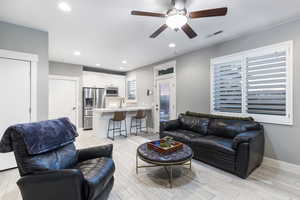 Living room with sink, ceiling fan, and light wood-type flooring