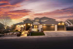 View of front of property featuring stucco siding, a tile roof, driveway, stone siding, and a garage