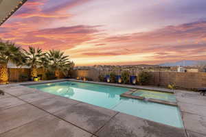 View of swimming pool featuring a fenced backyard, a mountain view, a patio, and a pool with connected hot tub