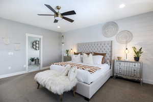 Carpeted bedroom with ceiling fan and ensuite bath