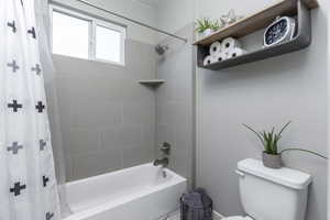 Bathroom featuring toilet and shower / bath combo