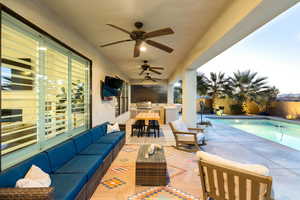 View of patio with area for grilling, grilling area, ceiling fan, an outdoor hangout area, and a fenced in pool